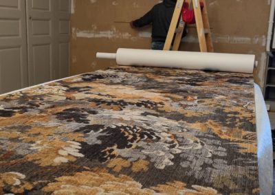 Préparation pour la pose d'un revêtement mural textile haut de gamme, imprimé végétal.