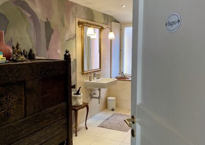 salle de bain mise en valeur par un papier peint spécialement choisi pour les endroits humides. Discret et élégant pour un espace de détente à proximité des clients.