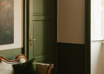 Salle principale du bed & Breakfast villa Oleandro. Peinture verte en soubassement, sur les portes et les cadres de fenêtre afin de mettre en valeur l'espace et la vue sur la vallée de Muggio.