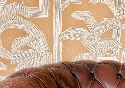 papier peint ARTE kailua- Pollen- 81504 en fond derrière un canapé vintage en cuir.