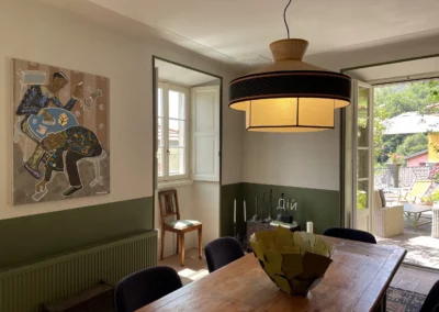 Salle de réception où les clients du Bed & Breakfast dinent. Décoration simple, soubassement de couleur verte et peinture claire pour le reste du mur.